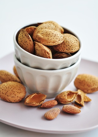 Almonds nuts in ceramic bowl on white backgroundの写真素材