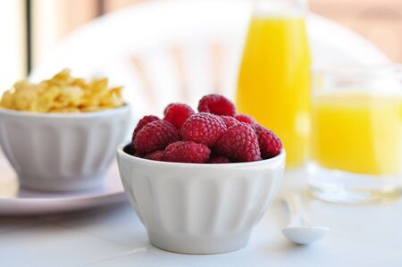 Fresh raspberry and corn flakes in ceramic bowl closeupの写真素材