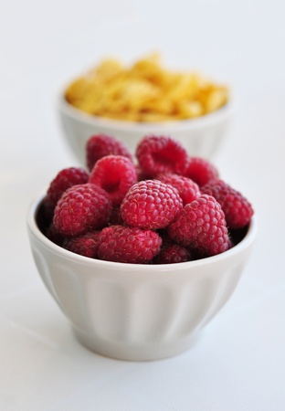 corn flakes and fresh raspberry  in ceramic bowl closeupの写真素材