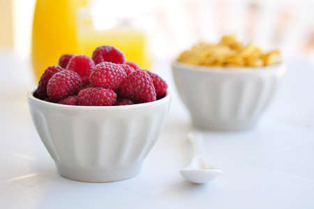 corn flakes and fresh raspberry  in ceramic bowl closeupの写真素材