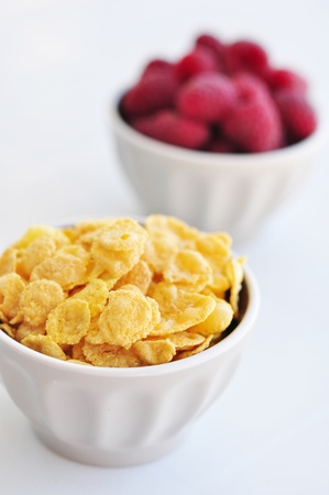 corn flakes and fresh raspberry  in ceramic bowl closeupの写真素材