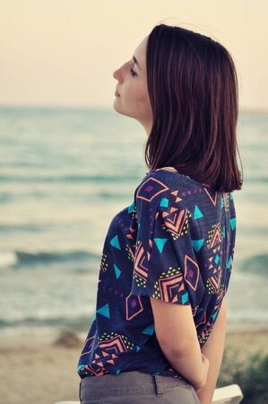 Beautiful girl on the beach during sunsetの写真素材