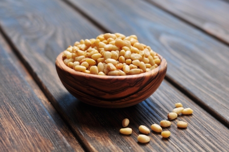 pine nuts in wooden bowl on wooden backgroundの写真素材