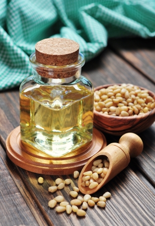 pine nuts oil in a glass jar on wooden backgroundの写真素材
