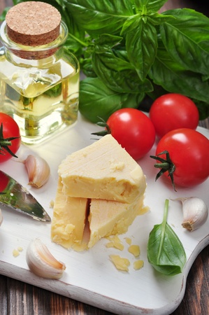 Parmesan cheese with tomatoes and basil on wooden backgroundの写真素材