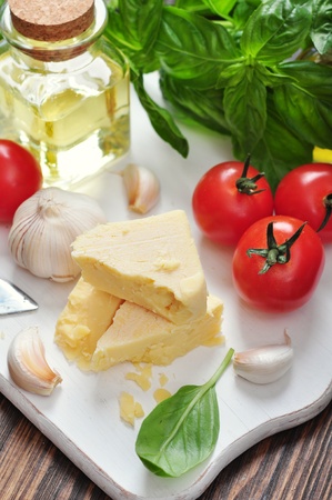 Parmesan cheese with tomatoes and basil in the backgroundの写真素材