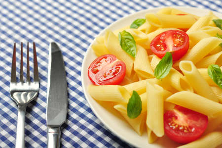 Penne pasta with cherry tomatoes and basil closeupの写真素材