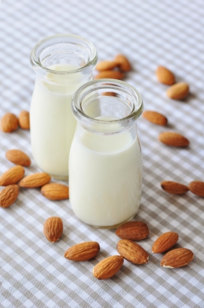 Almond with almond milk in glass bottles on a checkered backgroundの写真素材