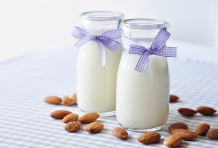 Almond  with almond milk in glass bottles on a checkered backgroundの写真素材