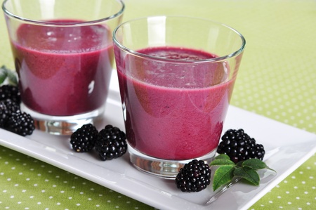 Blackberry smoothie with fresh blackberries on green backgroundの写真素材