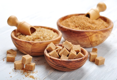 brown and white sugar in wooden bowls closeupの写真素材