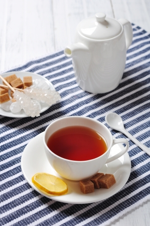 Cup with tea and teapot on blue striped backgroundの写真素材