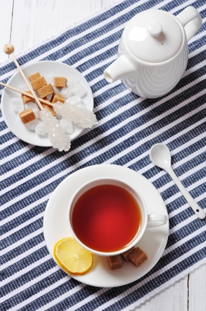 Cup with tea and teapot on blue striped backgroundの写真素材