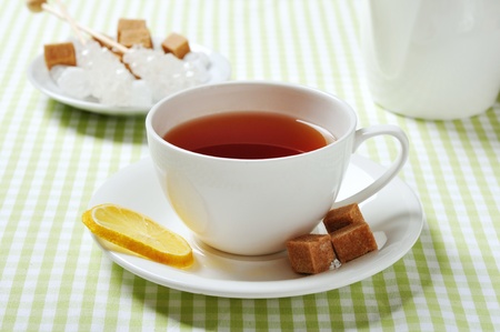 Cup with tea and lemon on green checkered backgroundの写真素材