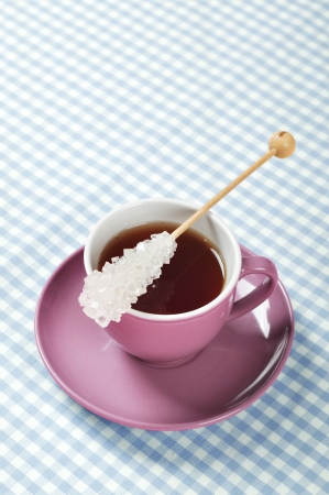 Tea in cup with candy sugar on checkered backgroundの写真素材