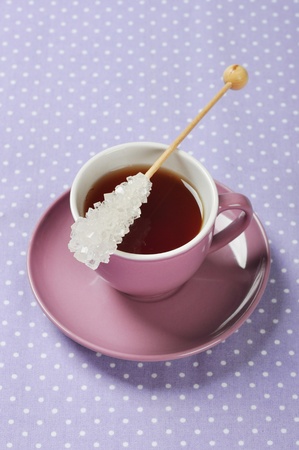 Tea in cup with candy sugar on polka dot backgroundの写真素材