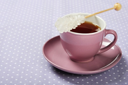 Tea in cup with candy sugar on polka dot backgroundの写真素材