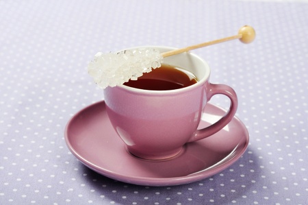 Tea in cup with candy sugar on polka dot backgroundの写真素材