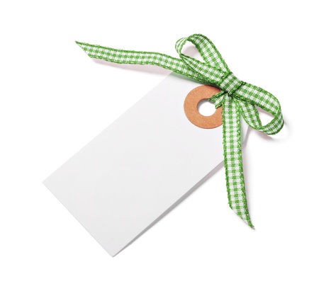 White tag with green ribbon bow isolated on whiteの写真素材