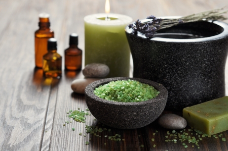 Spa concept. Sea salt in stone bowl with candle and herbal soapの写真素材