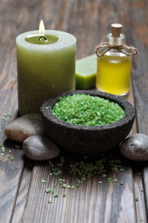 Spa concept. Sea salt in stone bowl with candle and herbal soapの写真素材