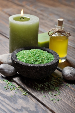 Spa concept. Sea salt in stone bowl with candle and herbal soapの写真素材