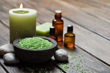 Spa concept. Sea salt in stone bowl with candle and herbal soapの写真素材