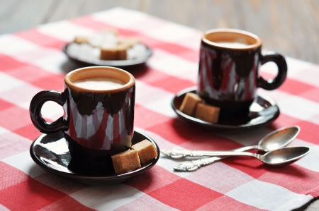 Two cups of espresso in brown cups on checkered napkinの写真素材