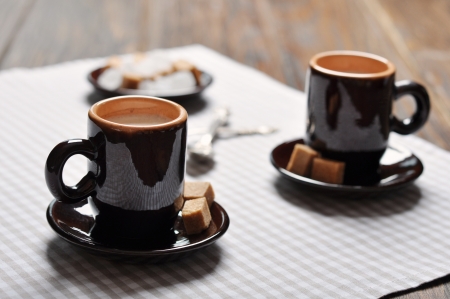Two cups of espresso in brown cups on checkered napkinの写真素材