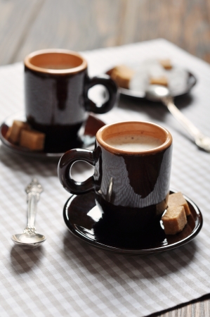 Two cups of espresso in brown cups on checkered napkinの写真素材