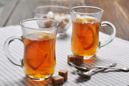 Tea with lemon in glass cups on checkered napkinの写真素材