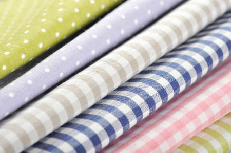 heap of  fabrics on wooden table closeupの写真素材