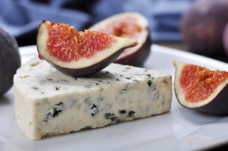 blue cheese and sweet fruit figs on a white plateの写真素材