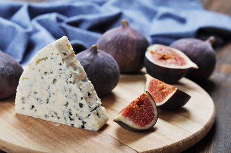 blue cheese and sweet fruit figs on a wooden boardの写真素材