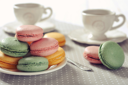 Traditional french pastry - macaroon with cup of tea on beige backgroundの写真素材