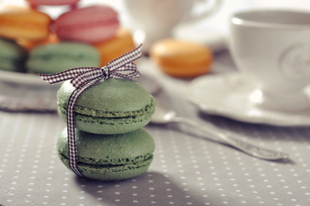 Traditional french pastry - macaroon with cup of tea on beige backgroundの写真素材