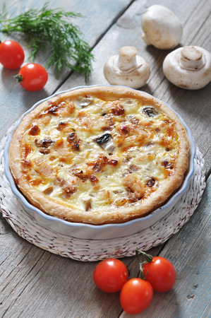 Traditional french quiche pie with chicken and mushroom  on a wooden backgroundの写真素材