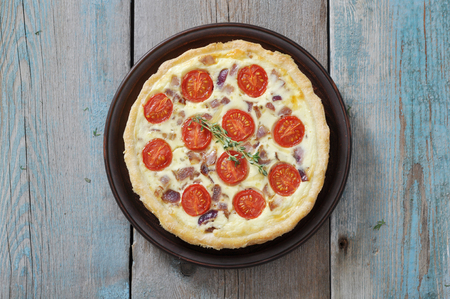 Traditional french quiche pie with chicken and cherry tomato  on a plateの写真素材