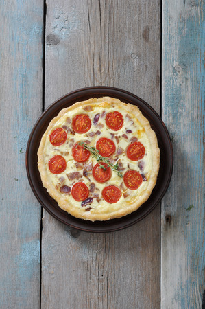 Traditional french quiche pie with chicken and cherry tomato  on a plateの写真素材