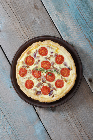 Traditional french quiche pie with chicken and cherry tomato  on a plateの写真素材