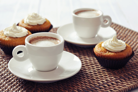 Cup of coffee with muffins on rattan placematの写真素材