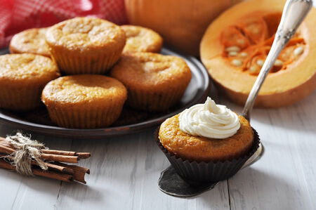Pumpkin Muffins on vintage wooden table with raw pumpkinの写真素材