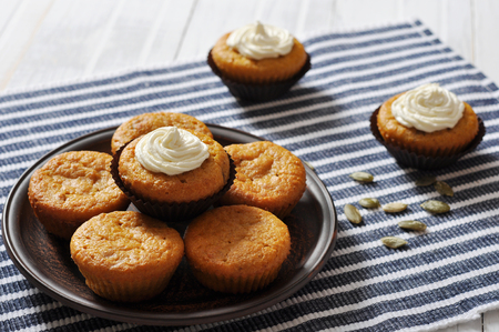 Pumpkin Muffins with whipped cream on blue striped backgroundの写真素材