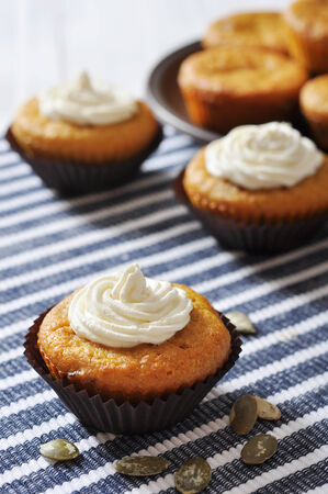 Pumpkin Muffins with whipped cream on blue striped backgroundの写真素材