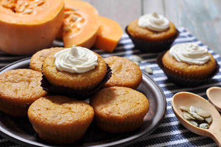 Pumpkin Muffins with whipped cream on blue striped backgroundの写真素材