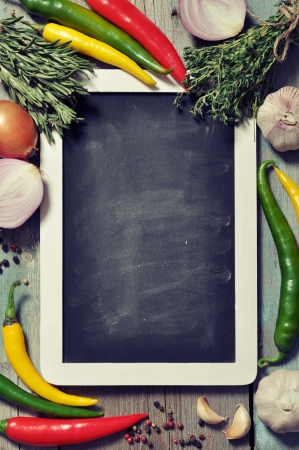 Slate board with fresh vegetables, spice and herbs on wooden background. Top view.の写真素材