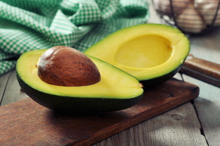 Fresh avocado on cutting board over wooden backgroundの写真素材