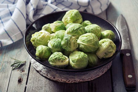 Fresh brussels sprout in bowl on wooden backgroundの写真素材