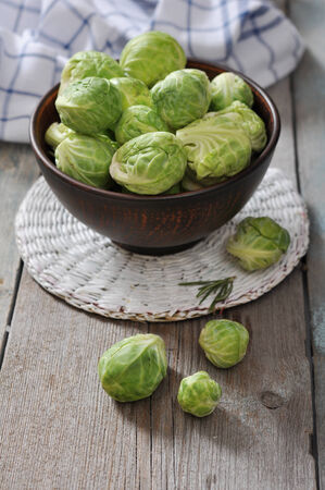 Fresh brussels sprout in bowl on wooden backgroundの写真素材