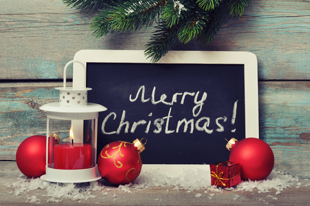 Christmas  decoration with candle in lantern and framed blackboard on wooden backgroundの写真素材